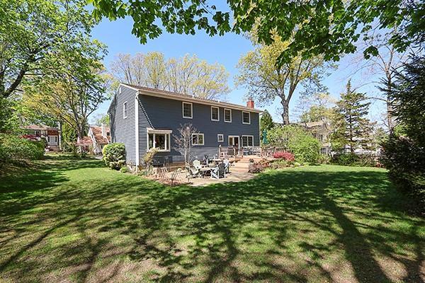 rear view of house featuring a lawn, a patio area, and a chimney