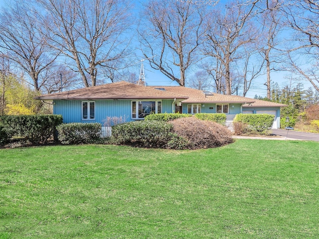 ranch-style house featuring a garage, concrete driveway, and a front yard