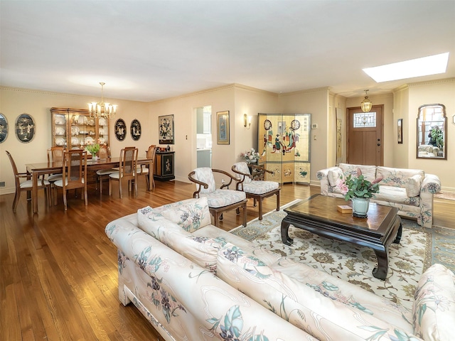 living area featuring a skylight, an inviting chandelier, and wood finished floors