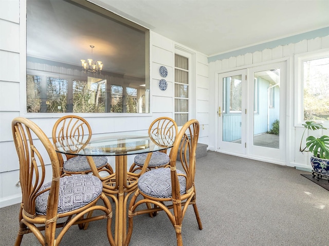 sunroom / solarium featuring an inviting chandelier and french doors