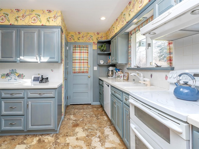 kitchen with white appliances, light countertops, under cabinet range hood, tasteful backsplash, and a sink
