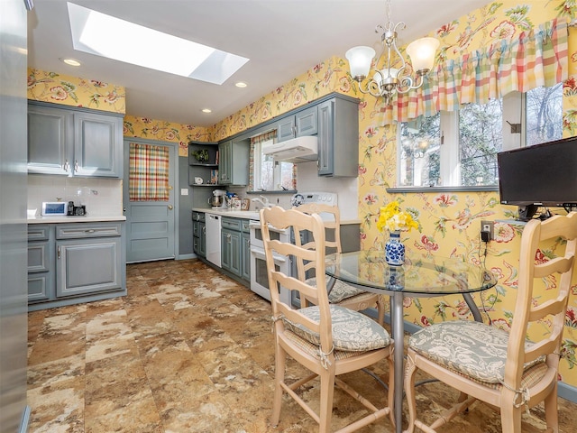 kitchen with a skylight, open shelves, light countertops, under cabinet range hood, and wallpapered walls