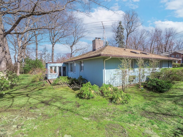 view of property exterior with a lawn and a chimney