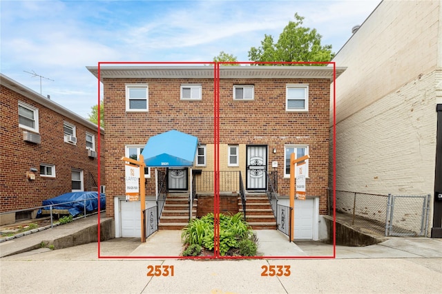 view of property with brick siding, fence, and a gate