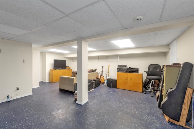 finished below grade area featuring a drop ceiling and baseboards