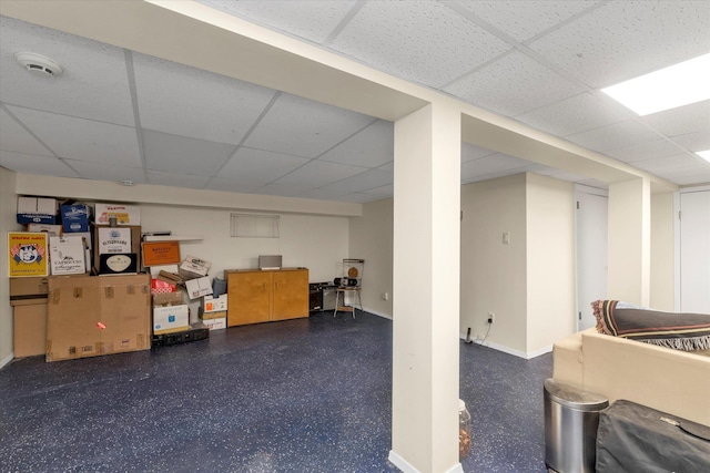 finished below grade area with a paneled ceiling and baseboards