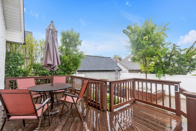 wooden terrace featuring outdoor dining area and fence