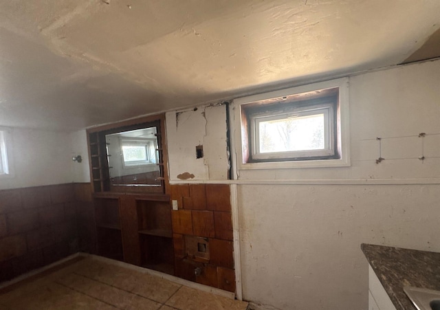 73 4th St, Brentwood, NY 11717 - bathroom with tile patterned floors and wainscoting