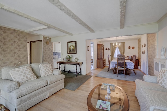 living room with a chandelier, light wood-style flooring, baseboards, wallpapered walls, and beamed ceiling