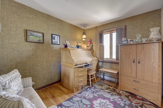 interior space with a baseboard heating unit and wood finished floors