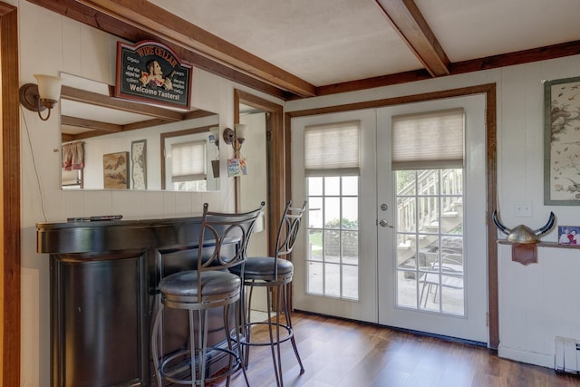 doorway to outside with bar area, beamed ceiling, french doors, and a baseboard heating unit