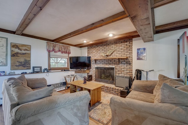 living area with beamed ceiling, wood finished floors, and a fireplace