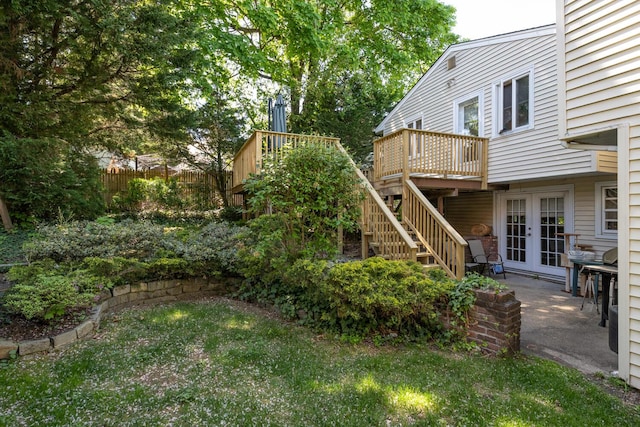 view of yard with stairs, a wooden deck, french doors, and fence