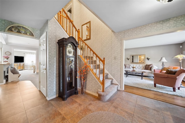 stairs with baseboards, tile patterned floors, and wallpapered walls