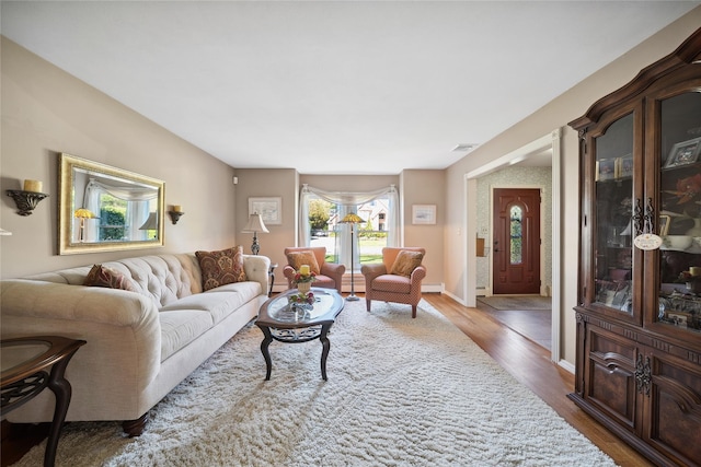 living area featuring baseboards and wood finished floors
