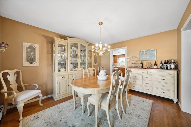 dining area featuring baseboards, a baseboard radiator, dark wood-type flooring, and a notable chandelier