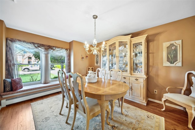 dining area with baseboards, a notable chandelier, light wood-type flooring, and a baseboard radiator