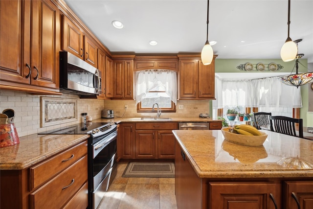 kitchen featuring a sink, light stone countertops, stainless steel appliances, and brown cabinets