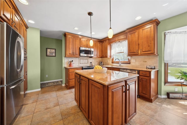 kitchen featuring baseboards, brown cabinetry, appliances with stainless steel finishes, and backsplash