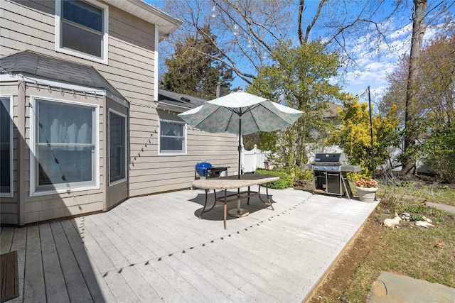 wooden deck with outdoor dining area and a grill