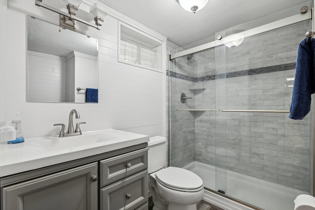 full bathroom featuring toilet, vanity, and a stall shower
