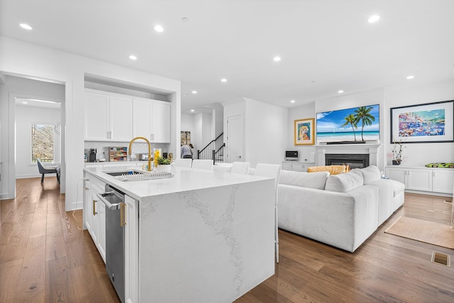 kitchen with visible vents, stainless steel dishwasher, dark wood-type flooring, recessed lighting, and a sink
