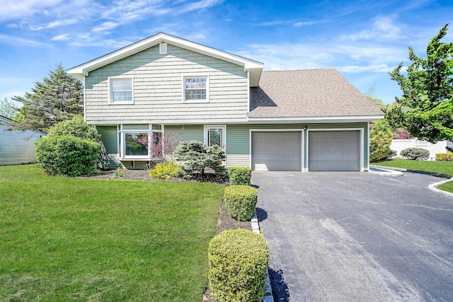 view of front of property featuring an attached garage, driveway, and a front yard