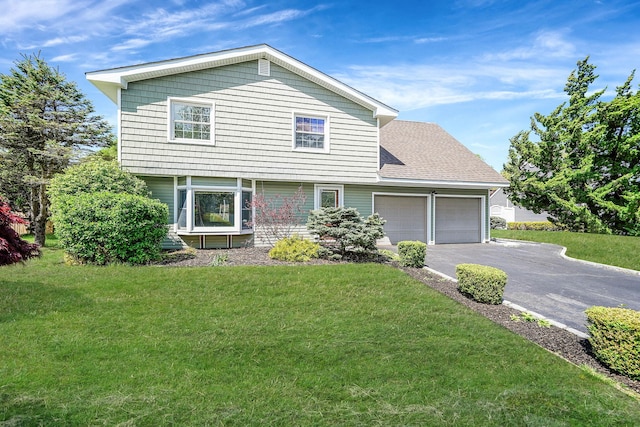 view of front of home featuring an attached garage, driveway, and a front lawn