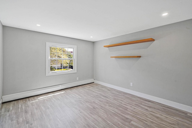 empty room featuring baseboard heating, wood finished floors, baseboards, and recessed lighting