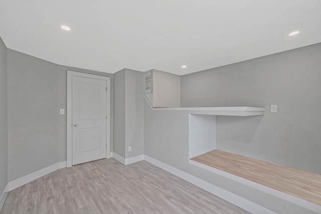 unfurnished room featuring wood finished floors, baseboards, and recessed lighting
