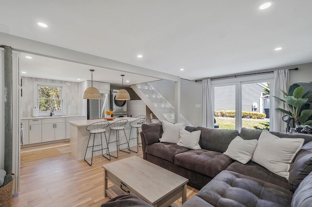 living area with stairway, light wood-type flooring, recessed lighting, and washer / clothes dryer
