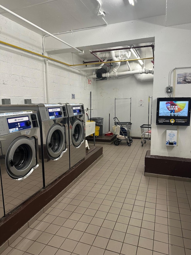 98-22 63rd Dr Unit 1E, Rego Park, NY 11374 - community laundry room featuring concrete block wall and washing machine and clothes dryer