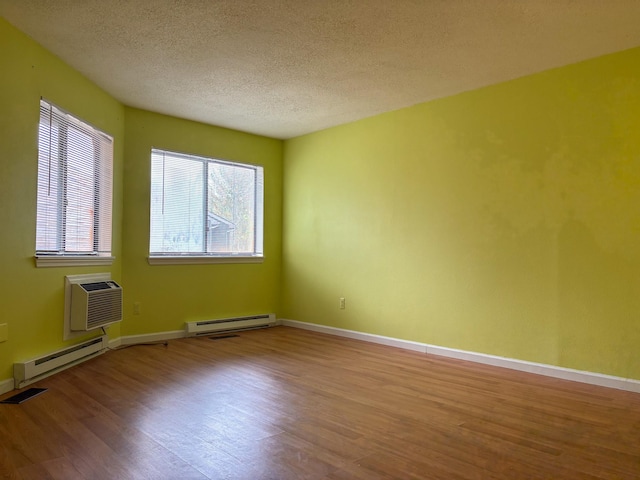 unfurnished room featuring a textured ceiling, a baseboard radiator, baseboards, and wood finished floors
