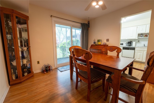 dining room with baseboards, a ceiling fan, and light wood-style flooring