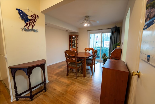 dining area featuring baseboards, a ceiling fan, and light wood-style flooring