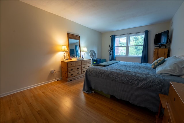 bedroom featuring baseboards and light wood finished floors
