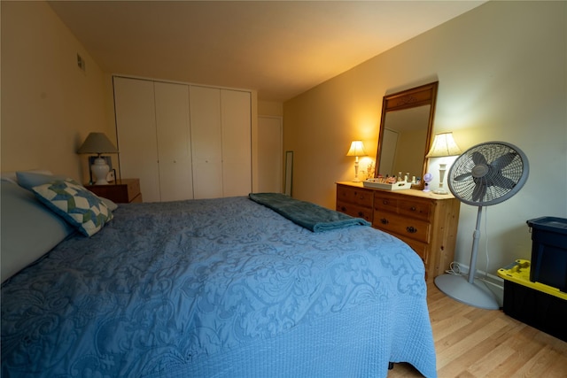 bedroom featuring a closet, light wood finished floors, and visible vents