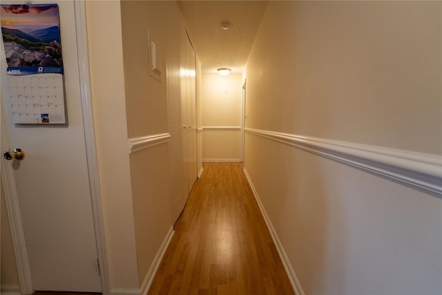 hallway with baseboards and light wood-style flooring