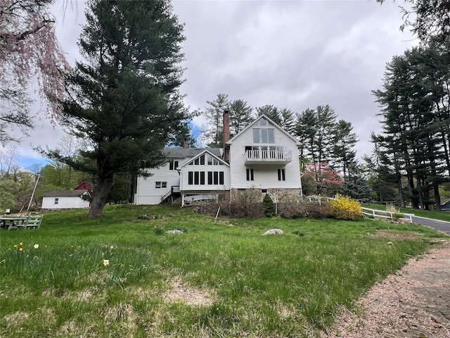 view of front of house with a chimney and a balcony