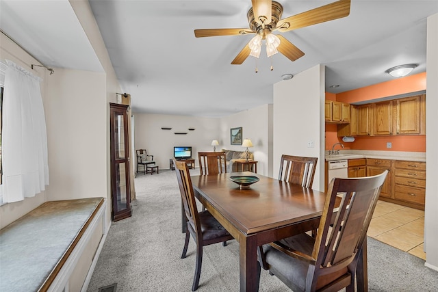 dining space featuring light colored carpet and ceiling fan