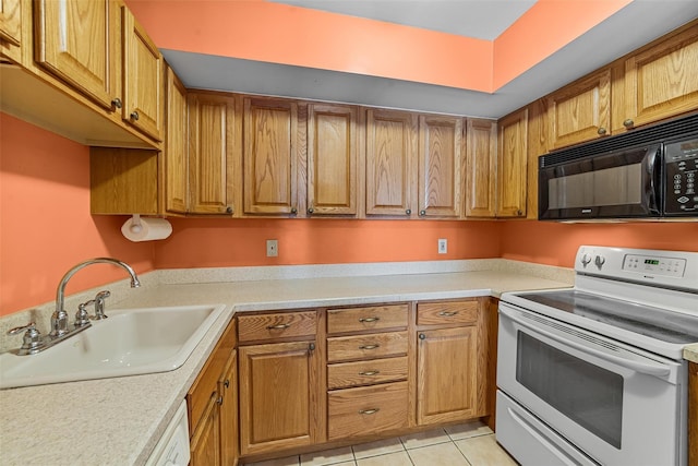 kitchen with a sink, brown cabinets, white appliances, and light countertops