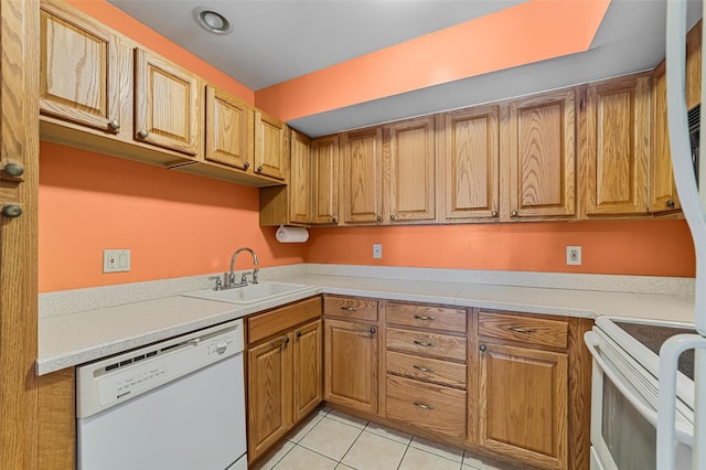 kitchen featuring brown cabinets, a sink, light tile patterned floors, light countertops, and white appliances