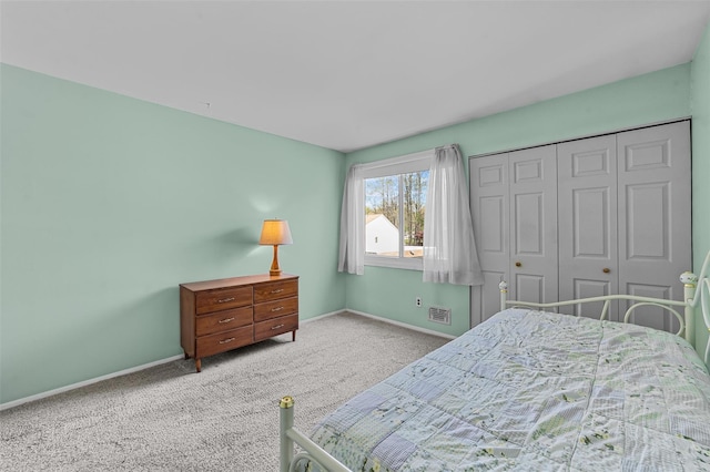 bedroom with visible vents, baseboards, carpet floors, and a closet