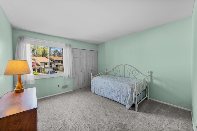 bedroom with carpet floors, baseboards, visible vents, and a closet