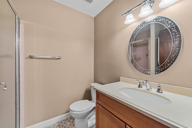 bathroom with vanity, a shower with door, and toilet