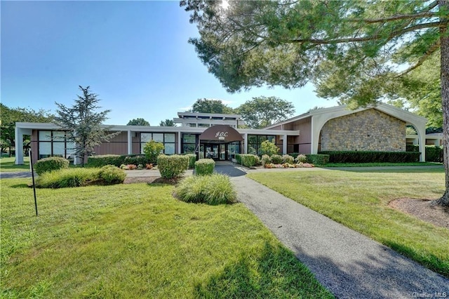 view of front of home with stone siding and a front lawn