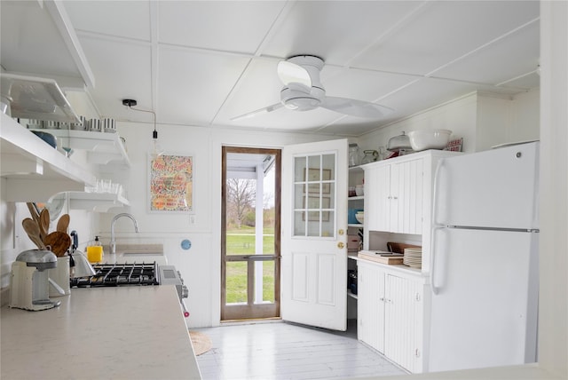 kitchen with a ceiling fan, open shelves, freestanding refrigerator, and light countertops