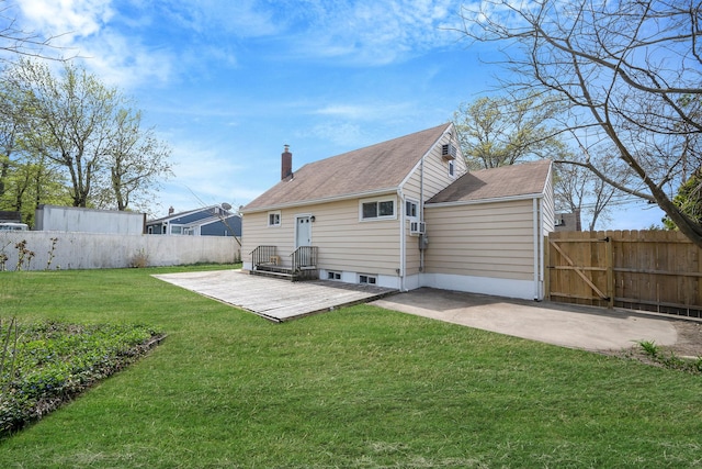 back of house with fence, a chimney, a lawn, and a patio area
