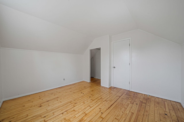 bonus room featuring baseboards, wood finished floors, and vaulted ceiling