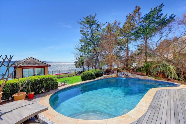 outdoor pool with a water view and fence